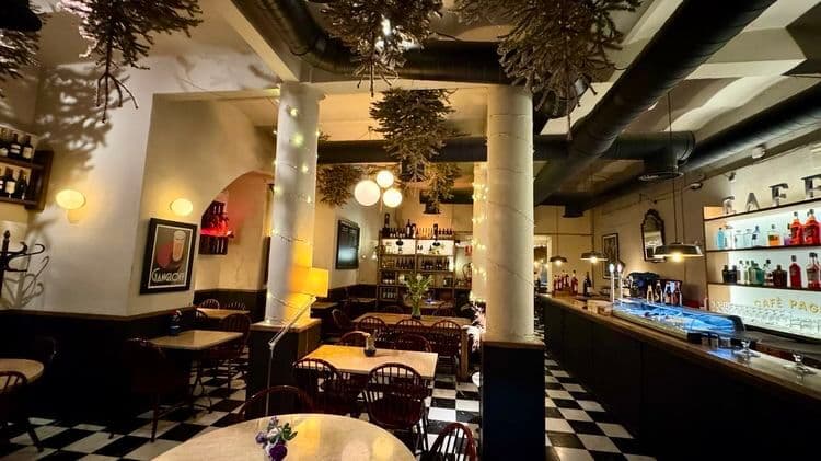 Interior lluminos de Café Pagès amb plantes, barra i taules al costat dels finestrals